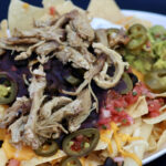 These piled-high nachos with salty and spicy ingredients would pair well with the fruity Apricot Hefeweizen.