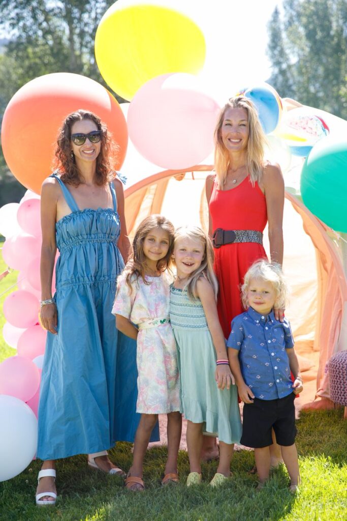 Two mothers and their children posing together at an outdoor Mother's Day Park City celebration.