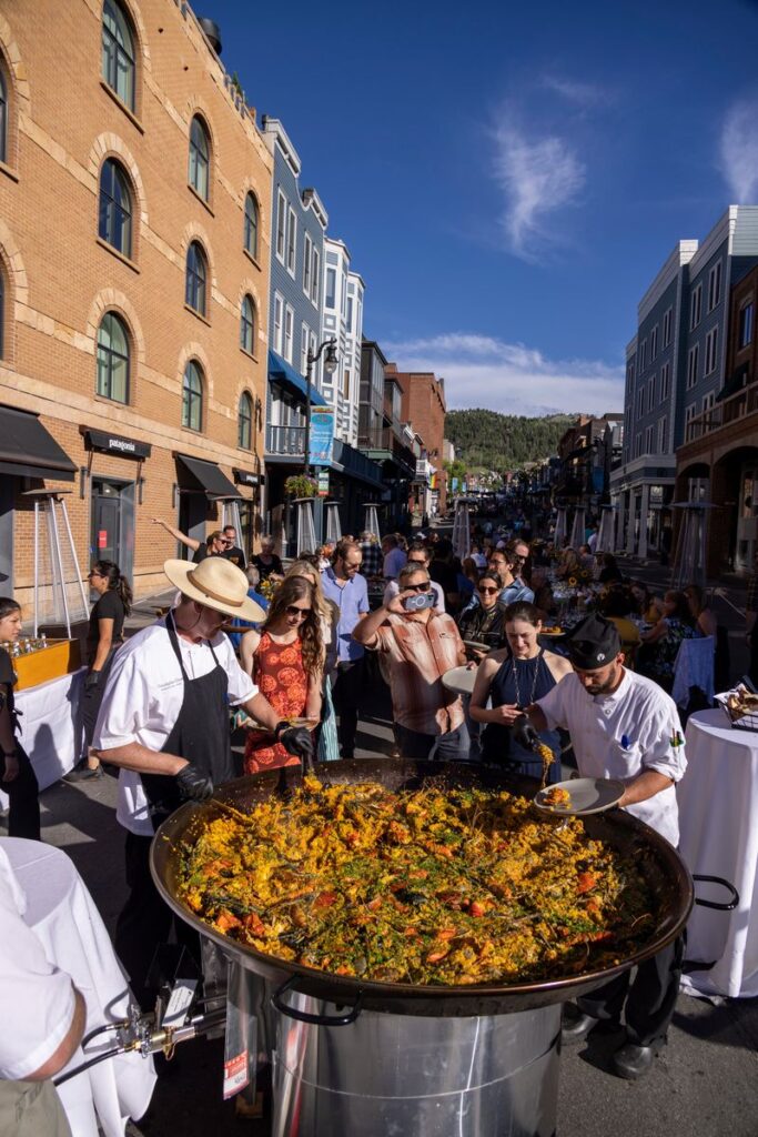 Chefs serve fresh paella from a legendary eight-foot wide outdoor pan on Main Street, showcasing the specialty deer valley dining experience at Savor the Summit.
